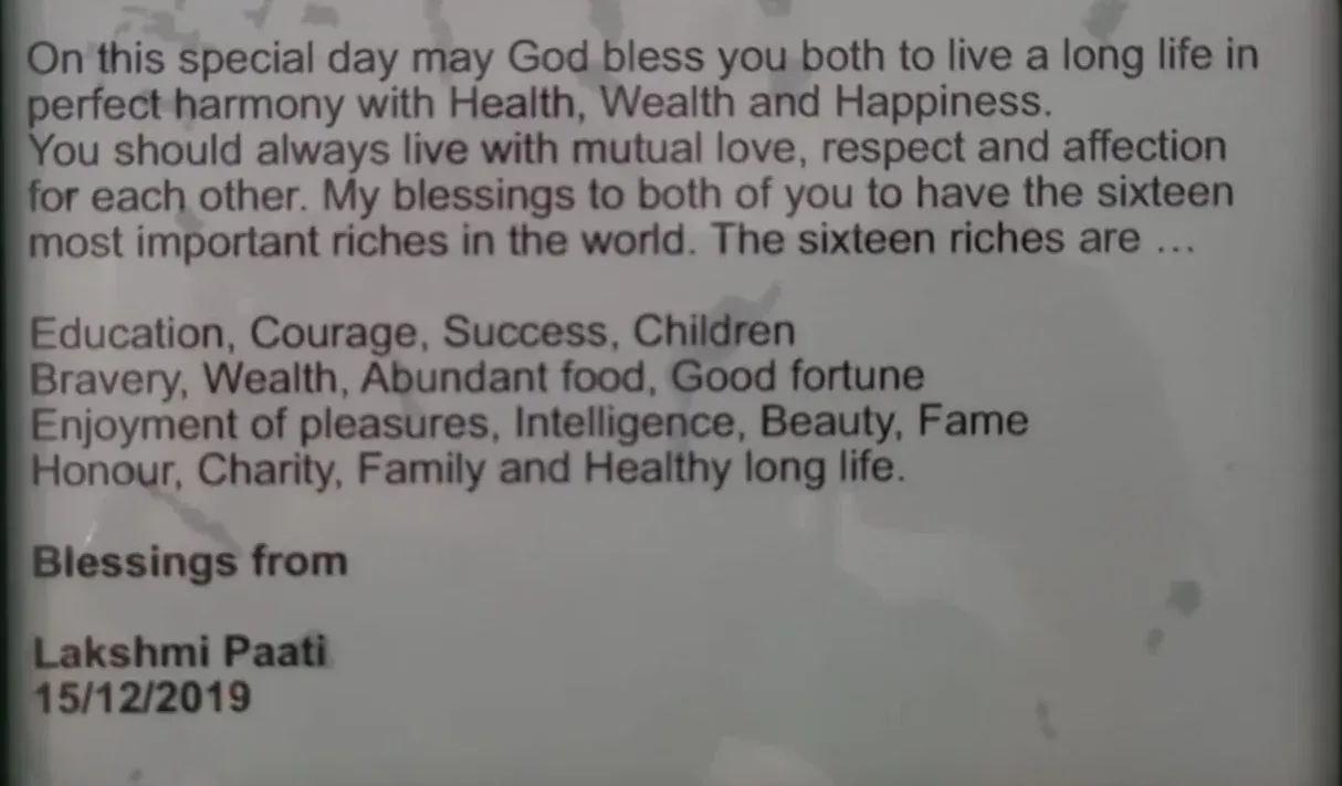 A typed card of blessings from Lakshmi Paati, dated 15 December 2019, listing the sixteen riches