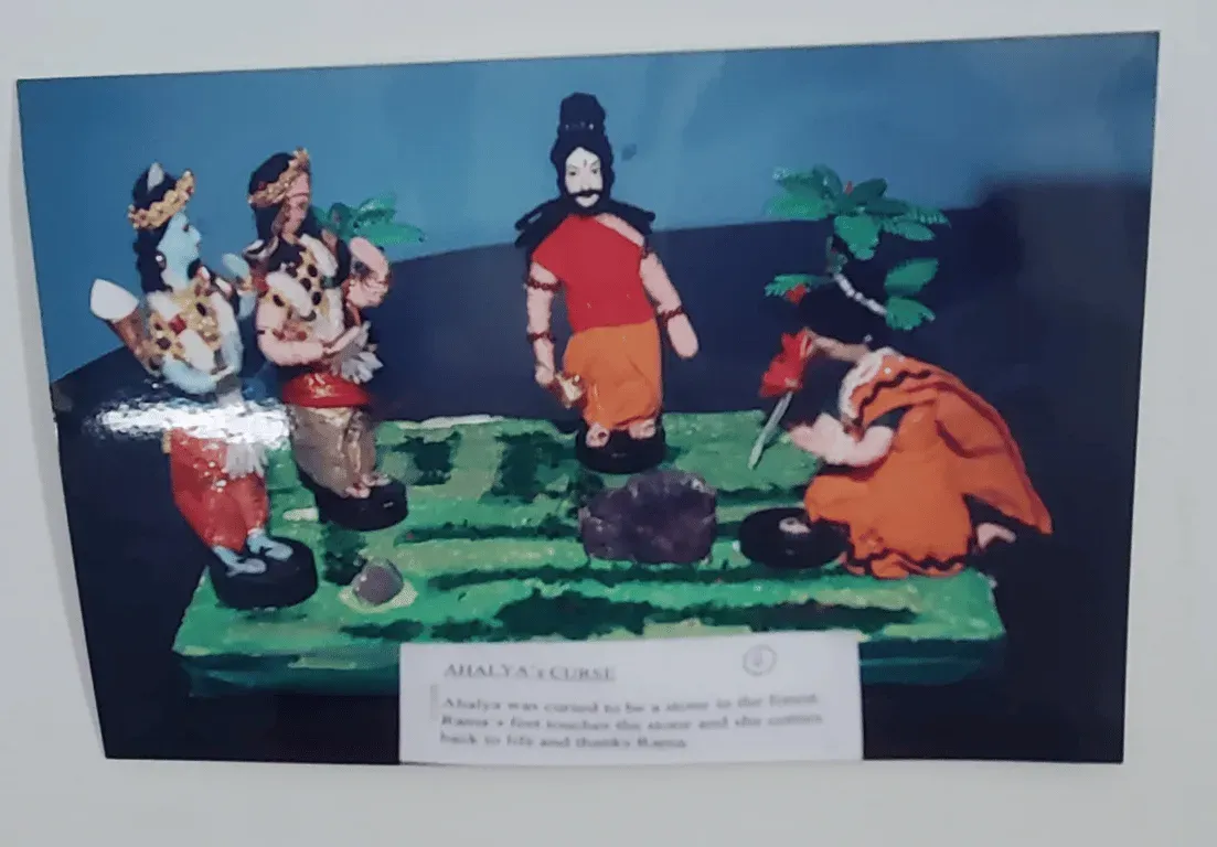 Doll scene of figures gathered around a bow in a court, with a typed caption card, from the Ramayana series