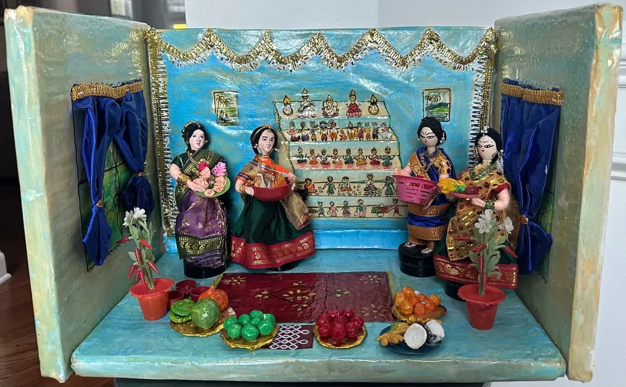 Painted box scene for Navaratri: a tiered golu of dolls with women visitors and small pots in front