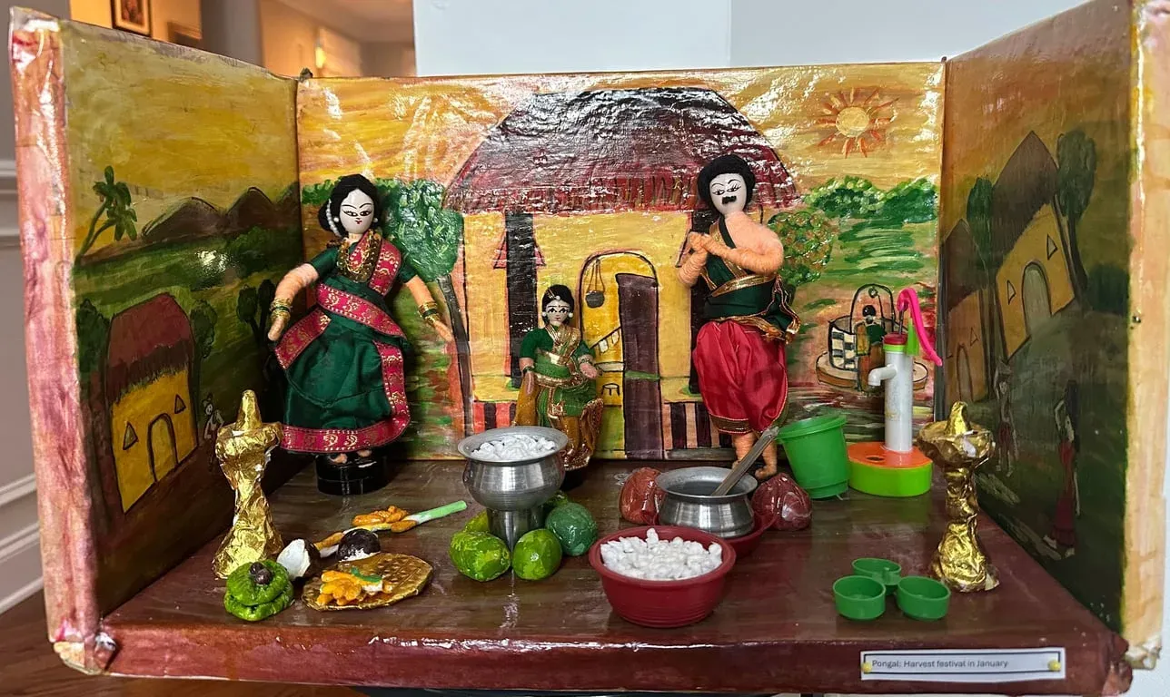 Painted box scene of a kitchen at Pongal: women at the stove with pots, vegetables and a lamp