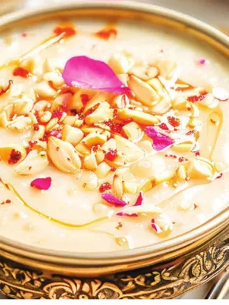 Badam kheer garnished with rose petals and chopped nuts